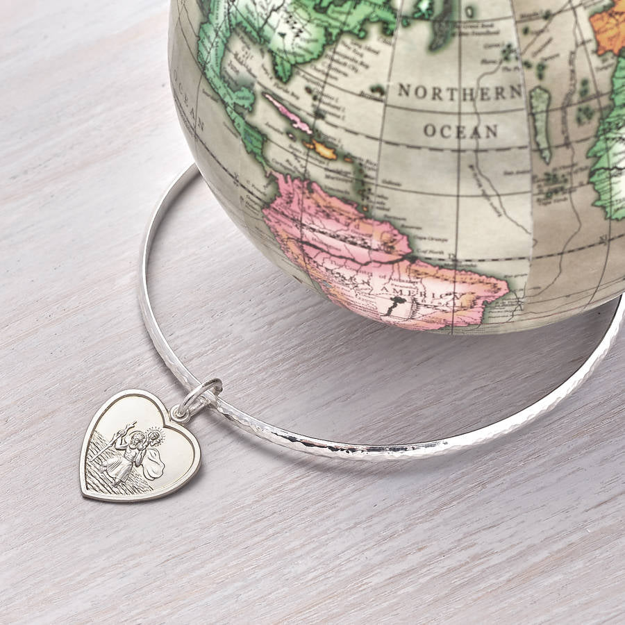 Silver hammered bangle with a St Christopher heart charm.